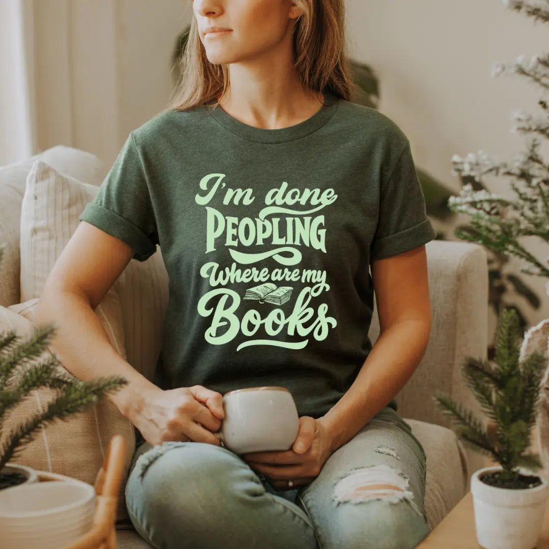 Winks Design Studio LLC I’m Done Peopling Where Are My Books T-shirt with humorous text and casual fit, displayed on a plain background.