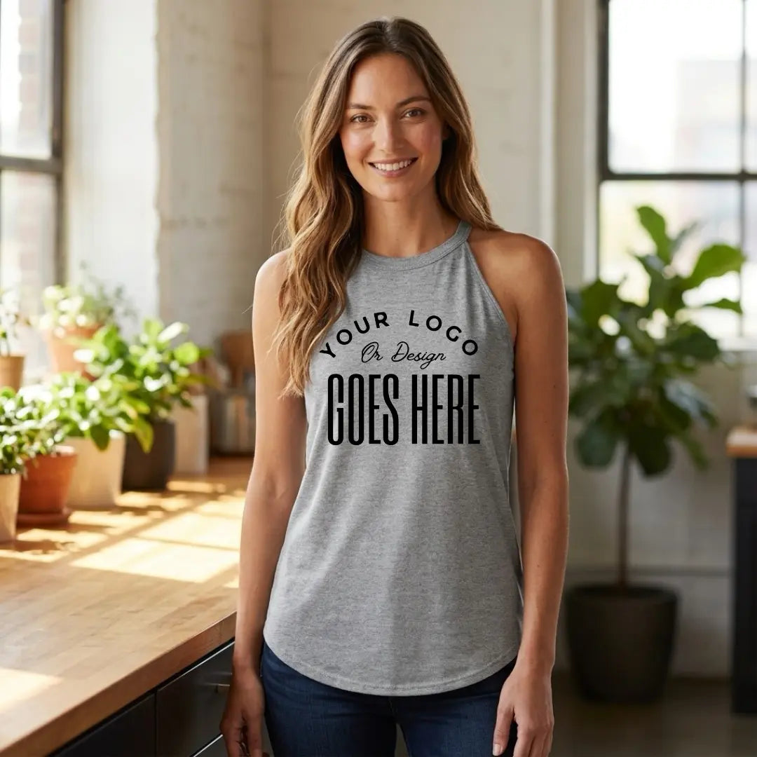 Woman in a heather gray custom high neck tank top with dark wash jeans in a bright, sunlit loft