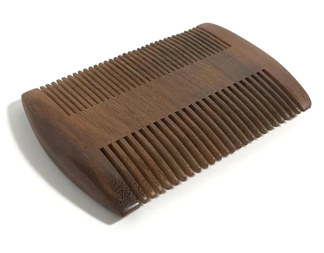 Custom engraved wood beard comb by Winks Design Studio, LLC with finely carved teeth and personalized engraving visible.