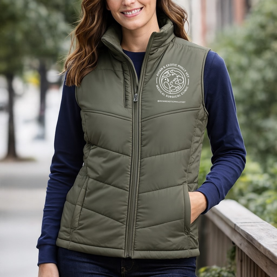 Woman wearing a green puffer vest with a logo, standing outdoors.