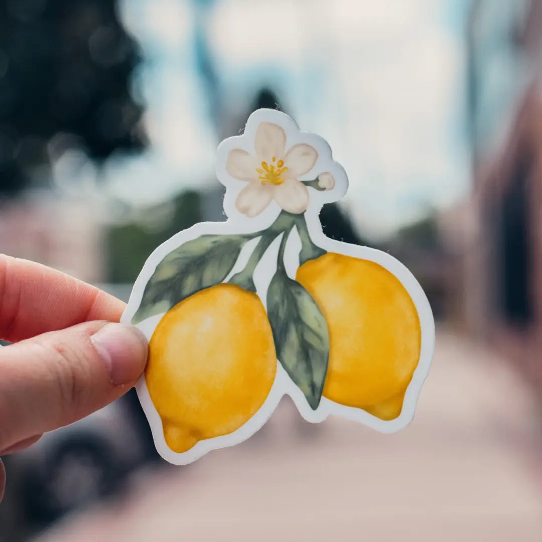 Lemon Blossom Waterproof Sticker by Winks Design Studio, LLC featuring vibrant lemon blossom floral design on a clear background.