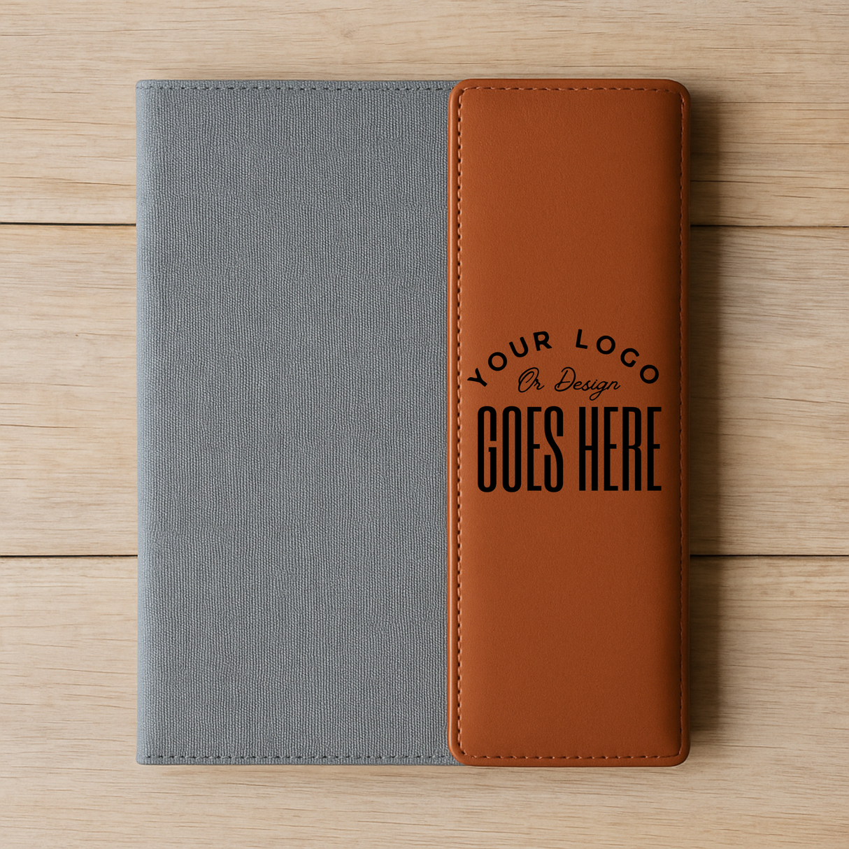 Two-tone gray and brown notebook with customizable text on a wooden surface