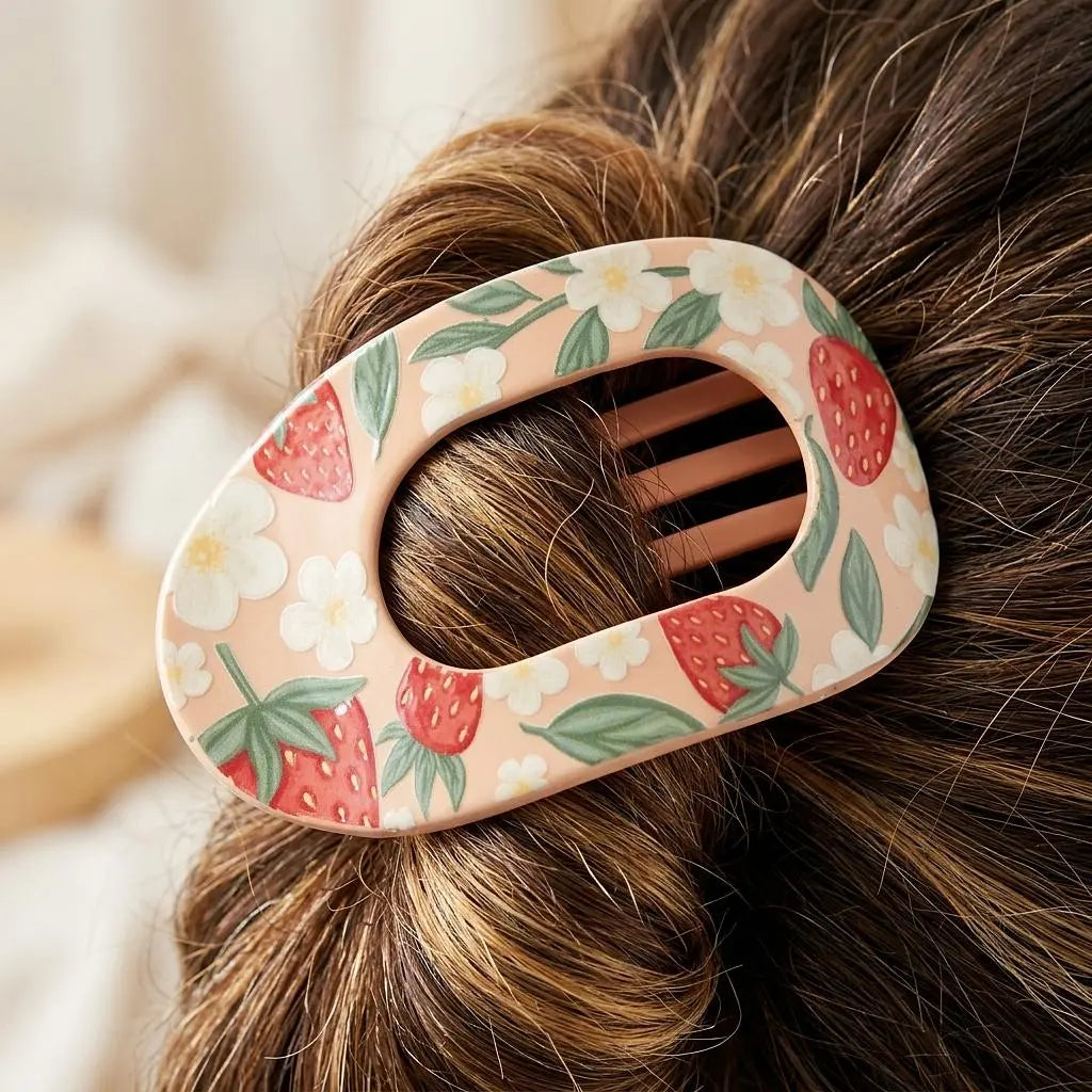 Winks Design Studio sweet summer strawberry claw clip holding hair, featuring red strawberry design and durable plastic construction.