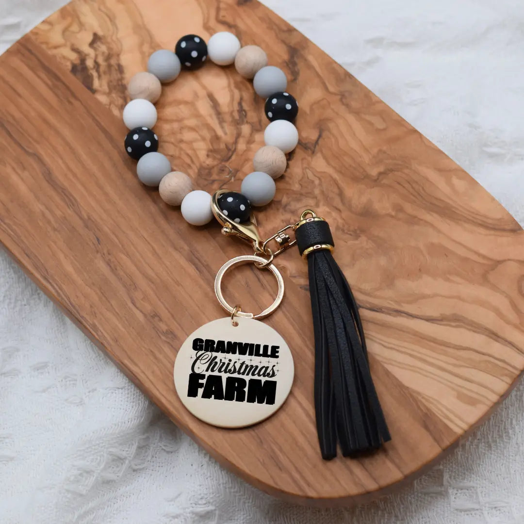 Granville Christmas Farm silicone wristlet keychain with festive holiday design, featuring colorful farm scene and Winks Design Studio branding