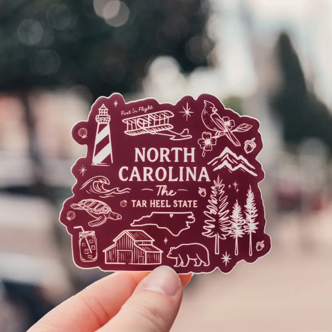 Illustrated North Carolina sticker featuring colorful map design, created by Winks Design Studio, LLC, ideal for decorating laptops or notebooks.