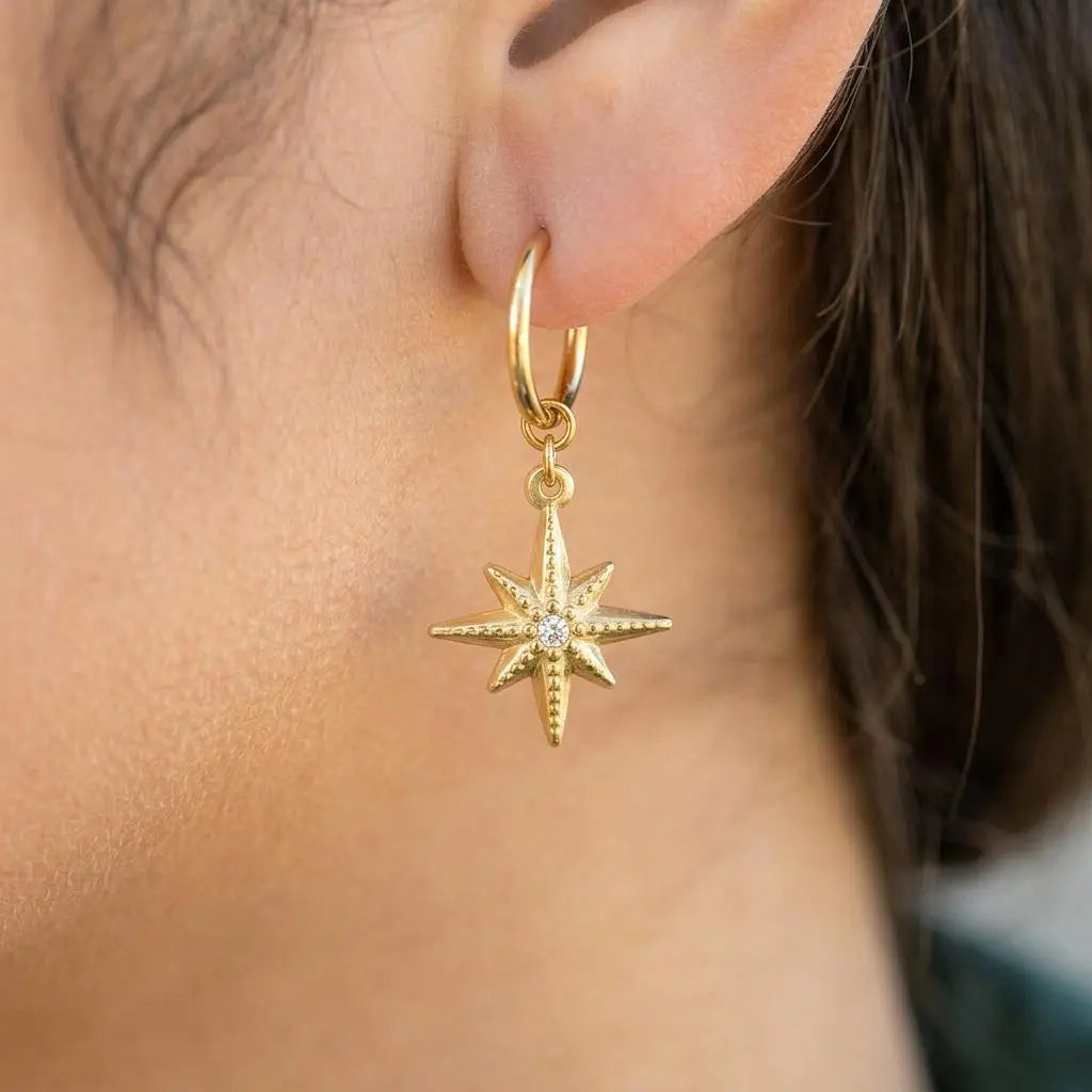 18K gold compass huggie earrings with CZ charm hoops by Winks Design Studio, LLC, featuring small, stylish hoop earrings with compass design.