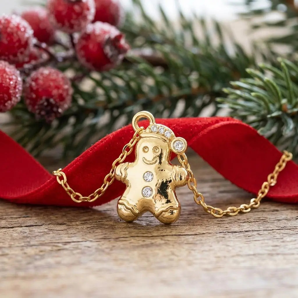 Gold cubic zirconia gingerbread man charm jewelry from Winks Design Studio, LLC, with detailed festive design and sparkling accents.