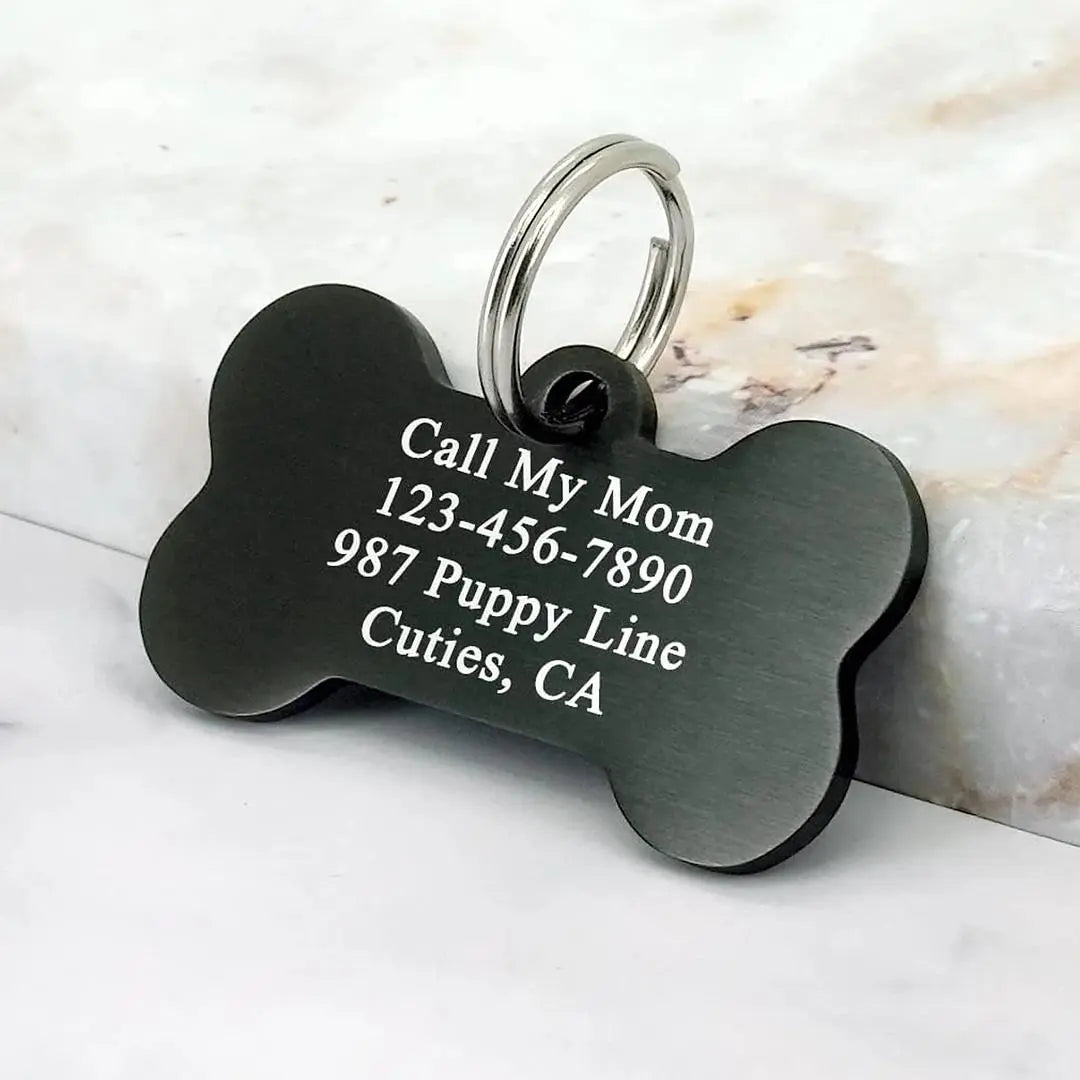 Custom engraved aluminum pet ID tag with bone shape from Winks Design Studio, LLC, featuring engraved pet details and durable design.