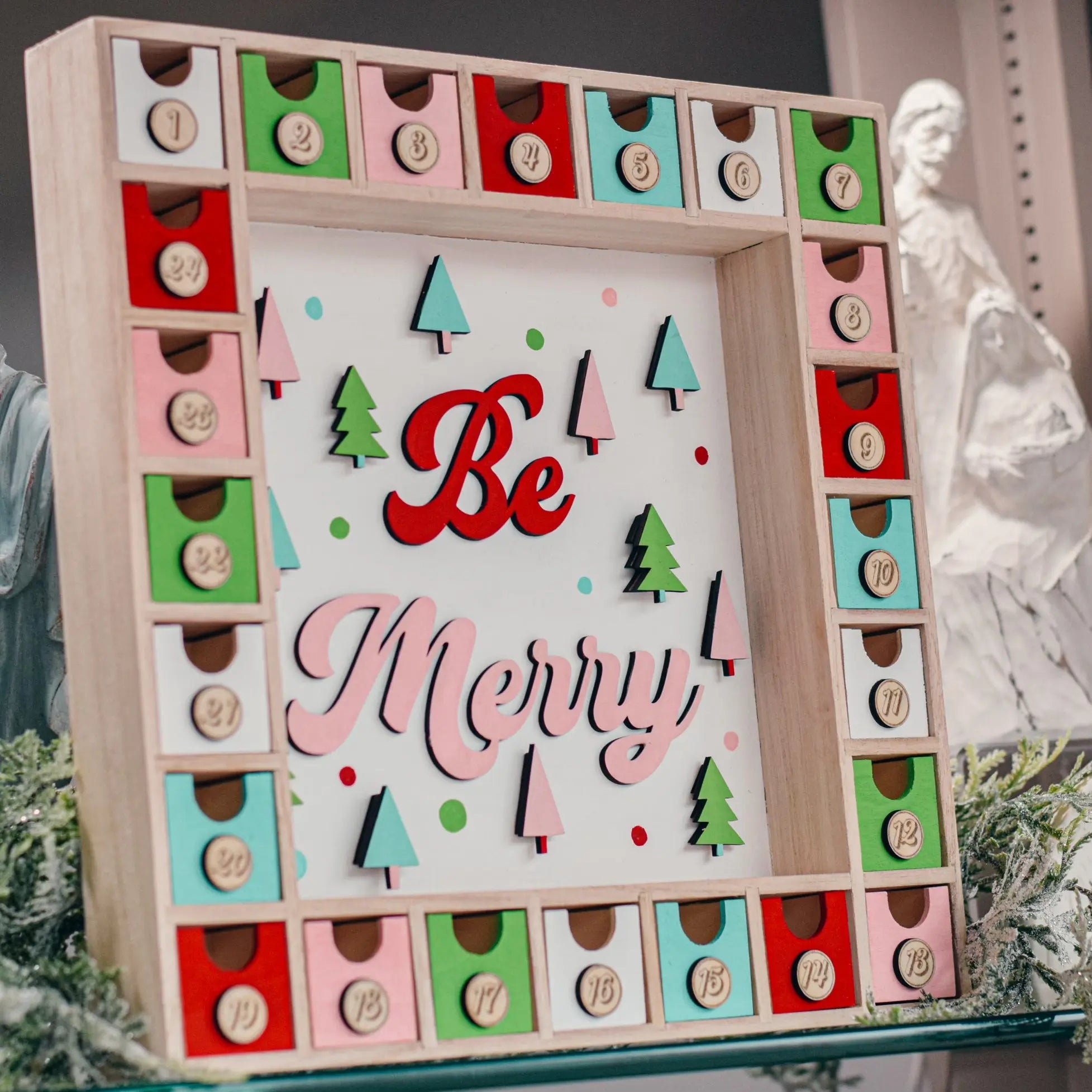 Winks Design Studio Be Merry Advent Calendar with numbered doors and festive holiday design, perfect for counting down to Christmas.