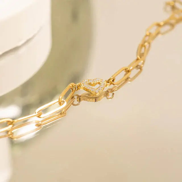 18K gold heart paperclip chain bracelet by Winks Design Studio, LLC features a stylish heart accents and sleek paperclip links.
