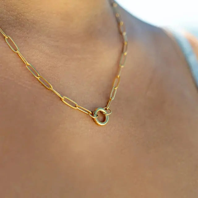 18K gold paperclip charm necklace by Winks Design Studio showing a close-up of the sleek chain with a small paperclip charm.