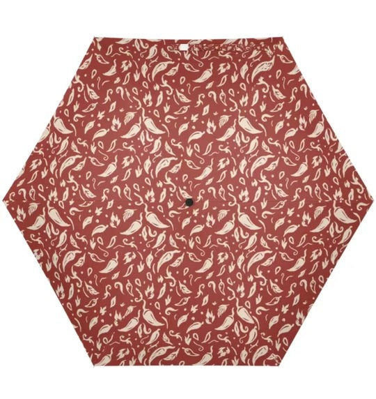 Hexagonal umbrella with a red and beige pattern on a white background