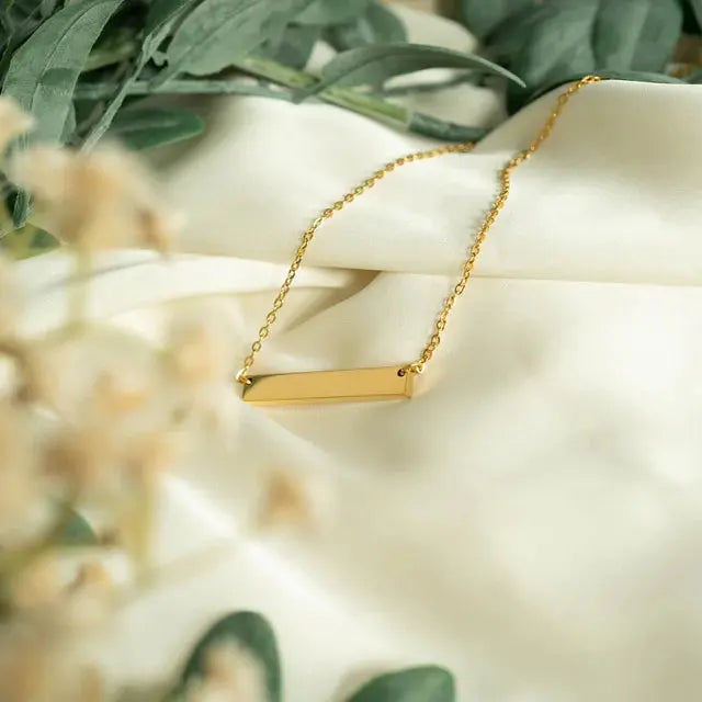 18K gold engraved bar necklace from Winks Design Studio, personalized stainless steel jewelry with a sleek, modern design.