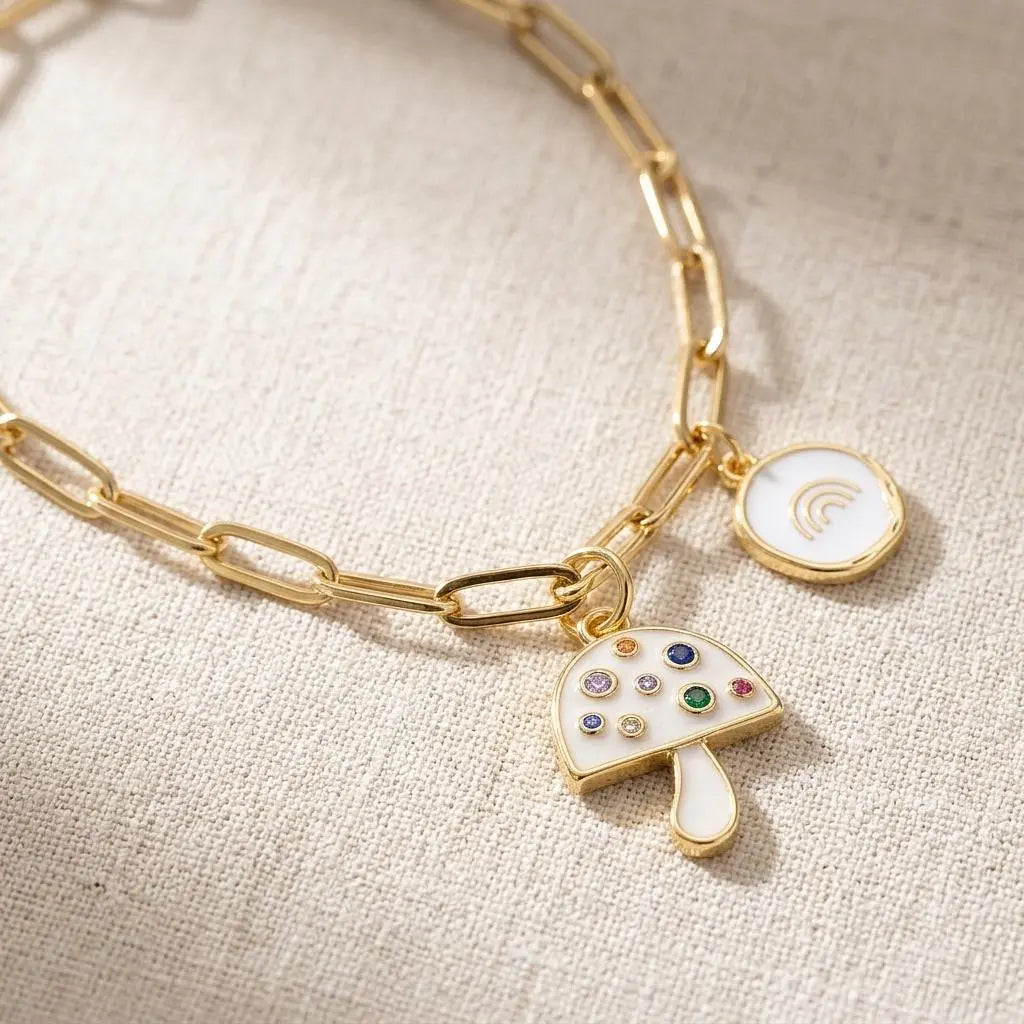 Gold and pearlescent mushroom charm jewelry piece with intricate details, crafted by Winks Design Studio, LLC.