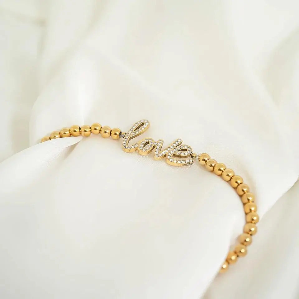 Love beaded stretch bracelet with 18K gold stainless steel beads, featuring a stylish and elegant design by Winks Design Studio.