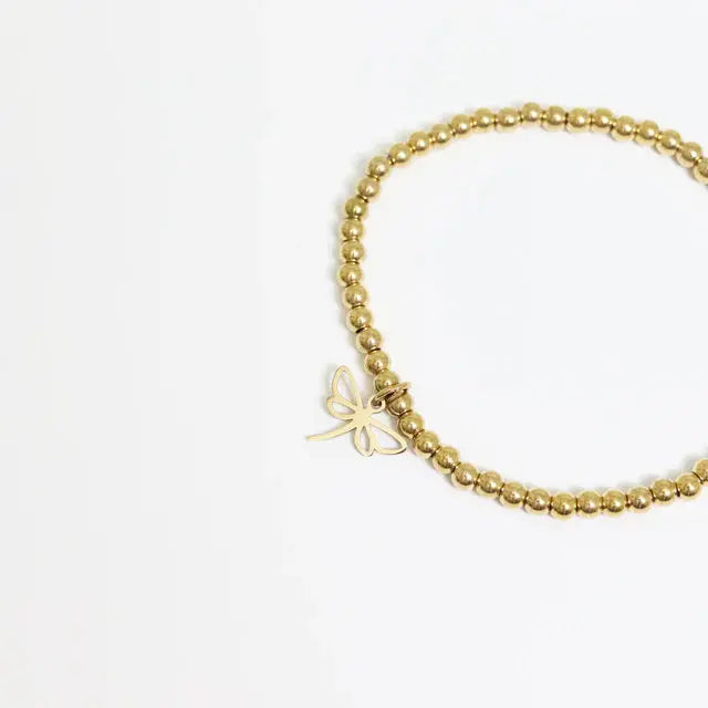 Gold dainty dragonfly charm from Winks Design Studio, LLC, featuring delicate details, ideal for charm bracelets or jewelry.