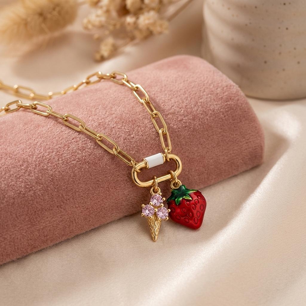 Gold enamel strawberry ice cream cone charm, summer jewelry accessory by Winks Design Studio, LLC, with detailed fruit and cone design.