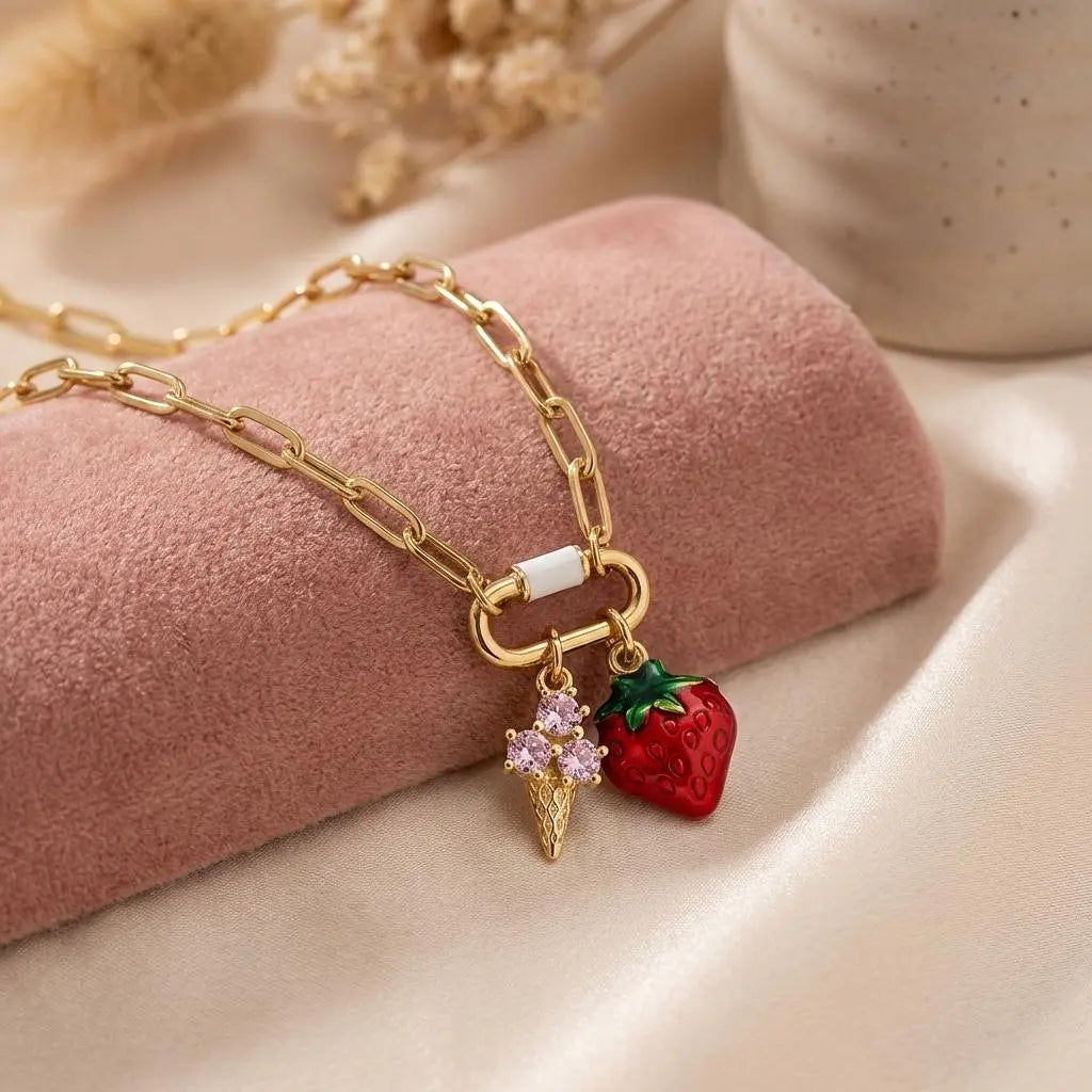 Gold enamel strawberry ice cream cone charm, summer jewelry accessory by Winks Design Studio, LLC, with detailed fruit and cone design.