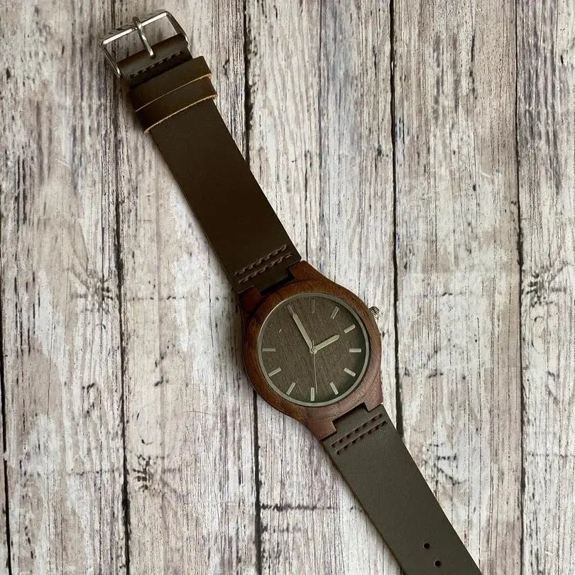 Walnut wood engraved watch by Winks Design Studio, LLC showing a close-up of the wooden watch face with engraved details.