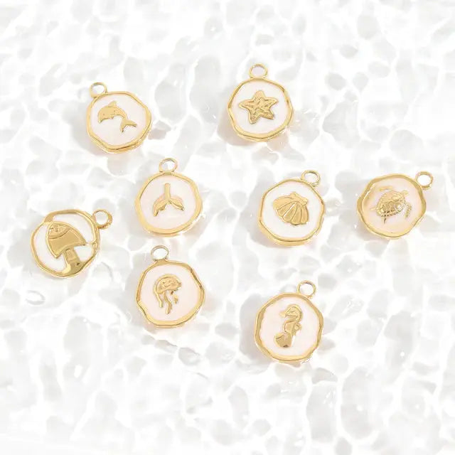 Gold sea life charm with epoxy finish, featuring ocean-inspired details, by Winks Design Studio, LLC.