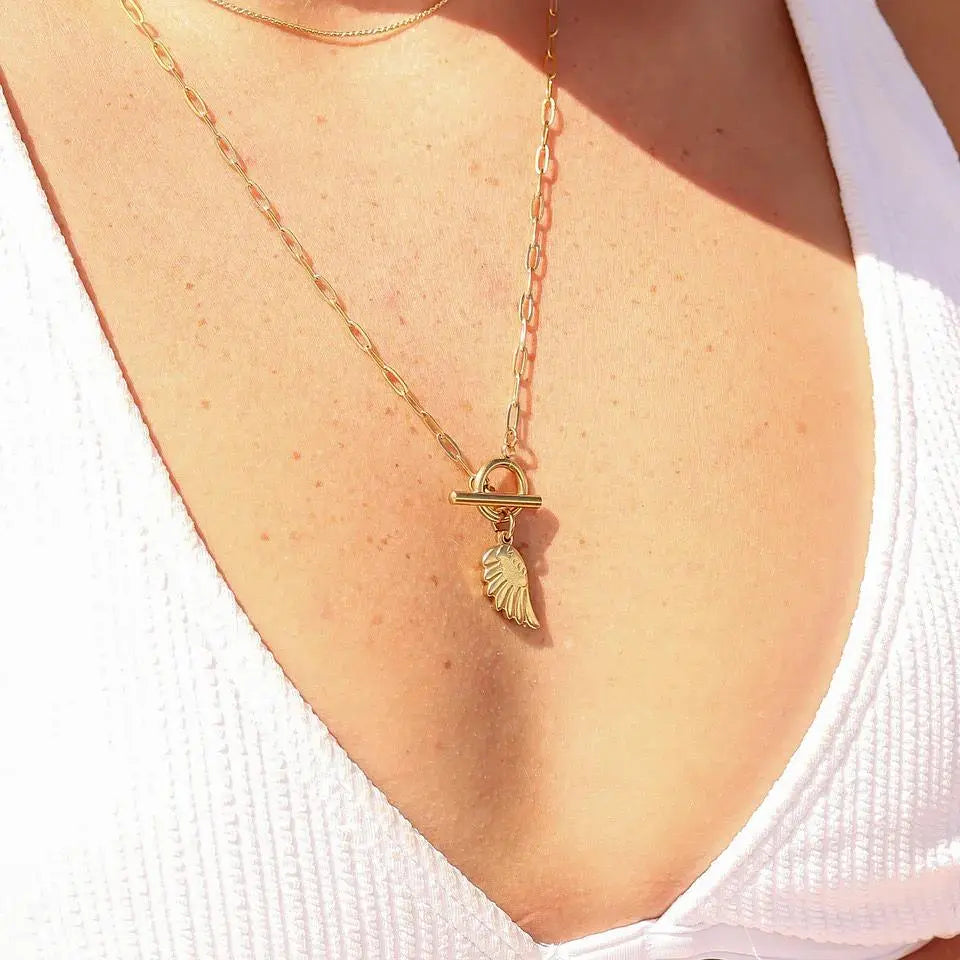 18K gold angel wing charm from Winks Design Studio, LLC, showcasing detailed feather design and shiny gold finish.