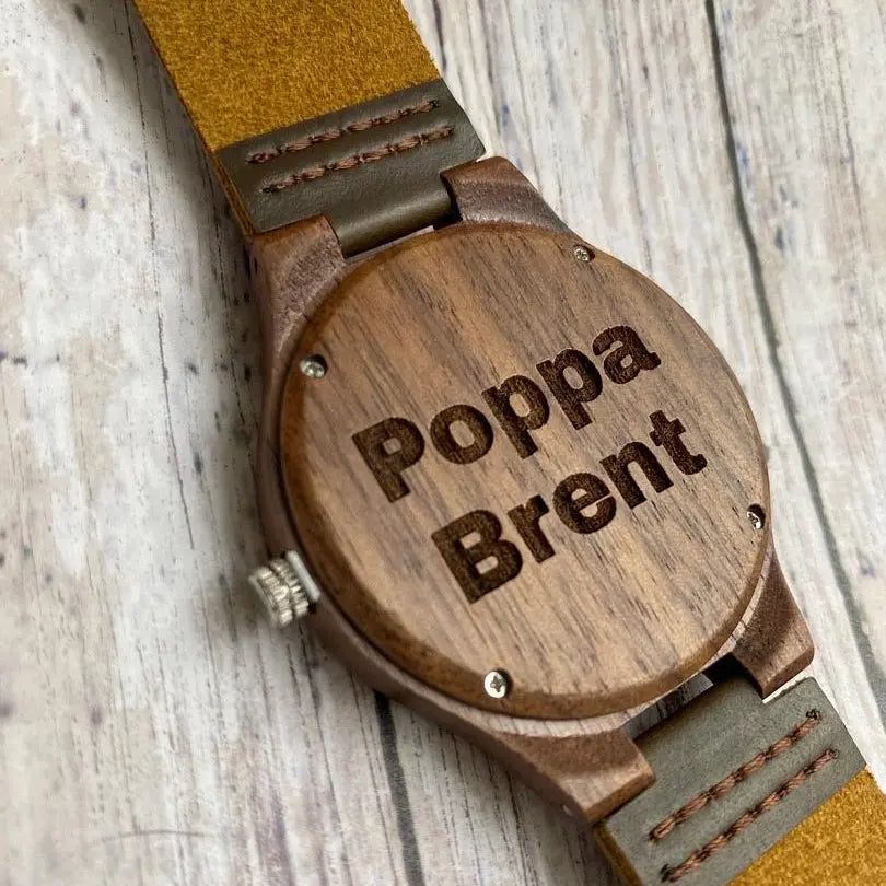 Walnut wood engraved watch by Winks Design Studio LLC showing a close-up of the wooden watch face and engraved details.
