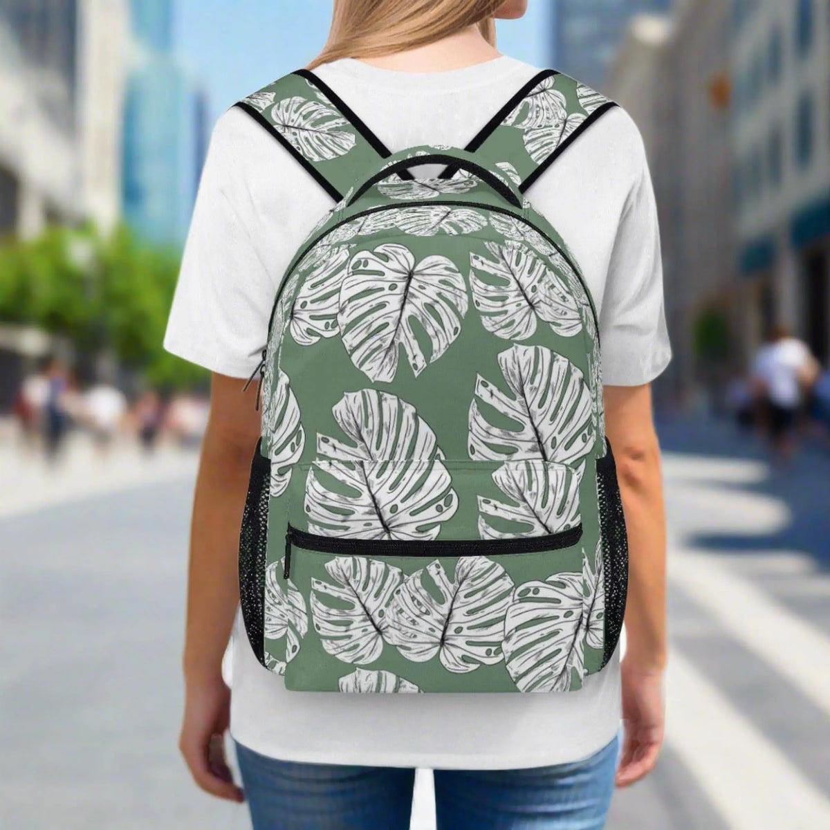 Green Monstera Leaves backpack by Winks Design Studio, LLC featuring tropical leaf pattern and adjustable straps.
