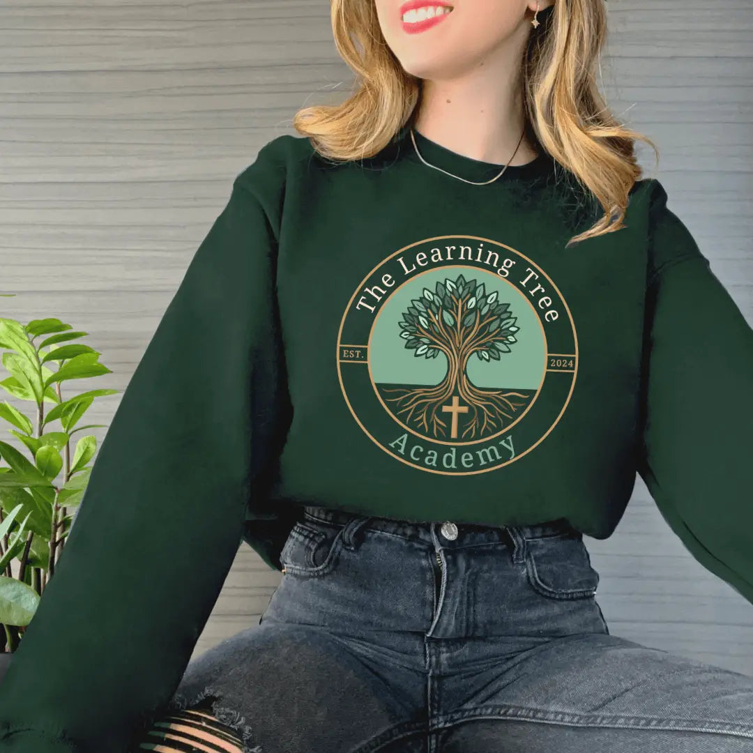 Forest green Winks Design Studio crewneck sweatshirt featuring The Learning Tree Academy logo, made from soft, comfortable fabric.