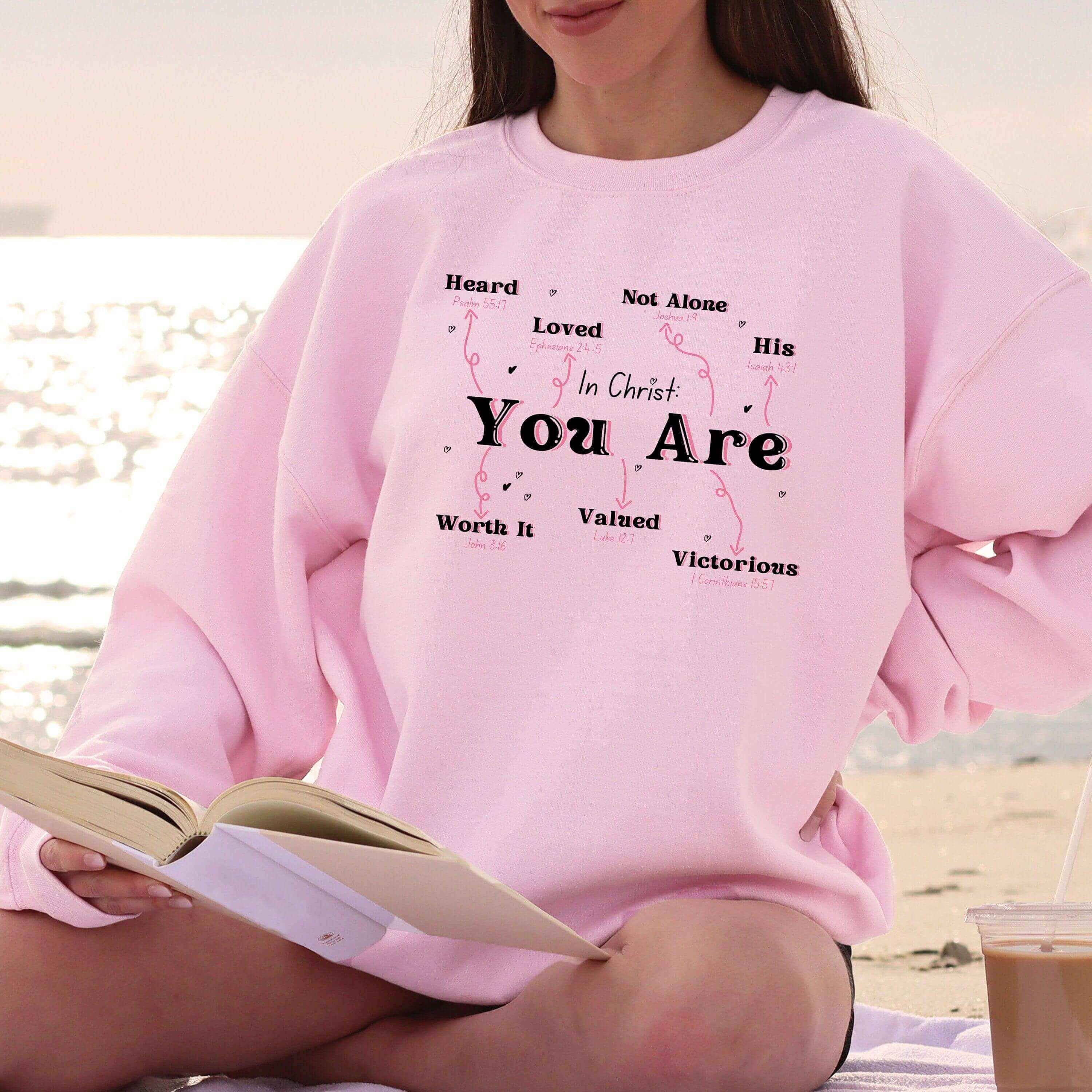 Small black crewneck sweater from Winks Design Studio LLC featuring the phrase "In Christ You Are" printed on the front.