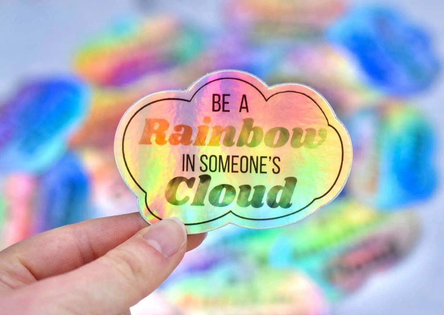 Decorative sticker from Winks Design Studio featuring a colorful rainbow with the phrase "Be A Rainbow In Someone&