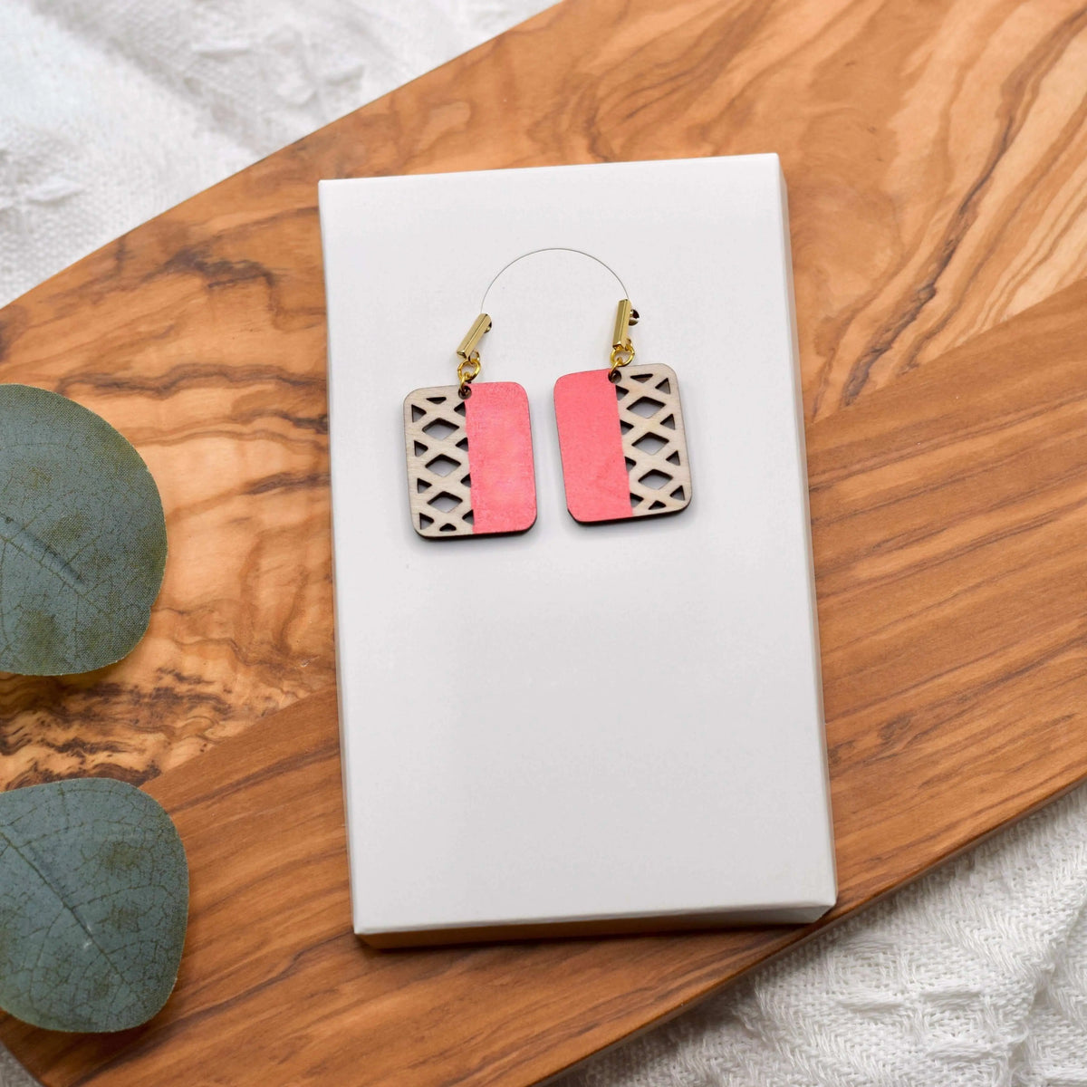 Colorful geometric wooden earrings by Winks Design Studio, LLC featuring vibrant blue shapes and modern design.