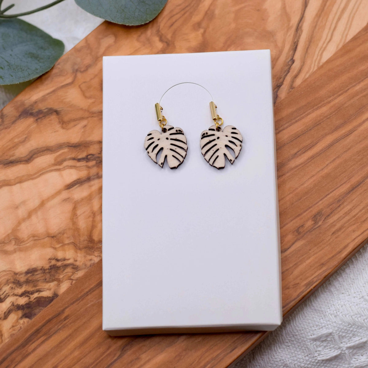 Wooden Monstera Leaf Earrings by Winks Design Studio, LLC, featuring natural wood texture and tropical leaf design.