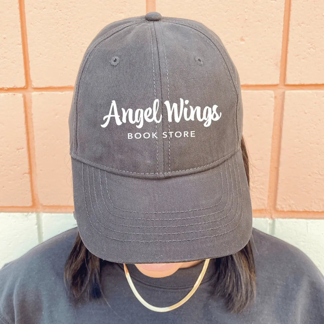 White twill hat with angel wings embroidery by Winks Design Studio, LLC, featuring a stylish and casual bookstore-themed hat.