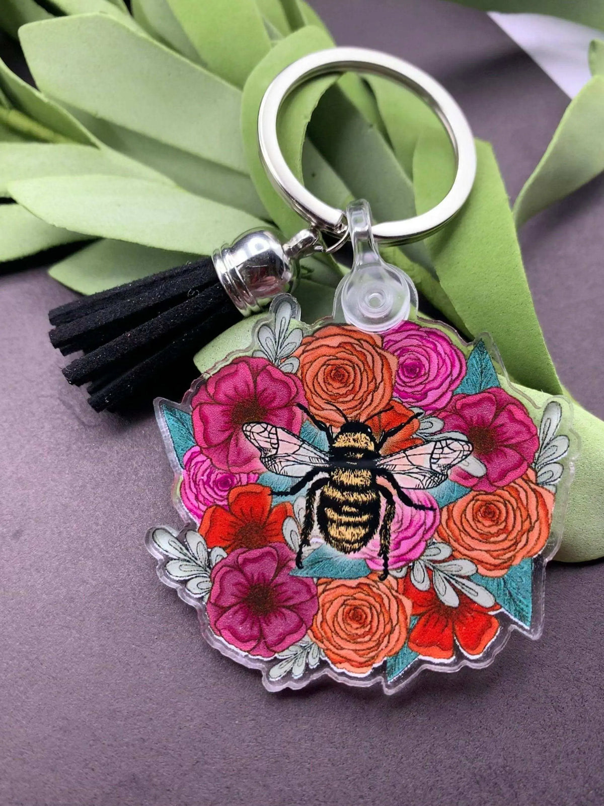 Bee and flowers keychain from Winks Design Studio, LLC featuring a detailed bee charm surrounded by colorful flower accents.