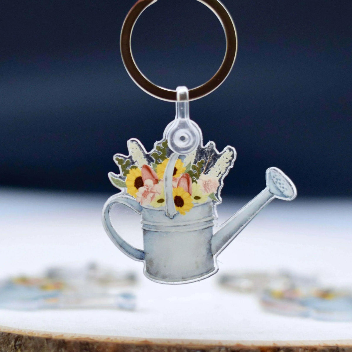 Watering Can with Flowers keychain by Winks Design Studio, LLC, featuring a detailed miniature watering can with colorful flower accents.