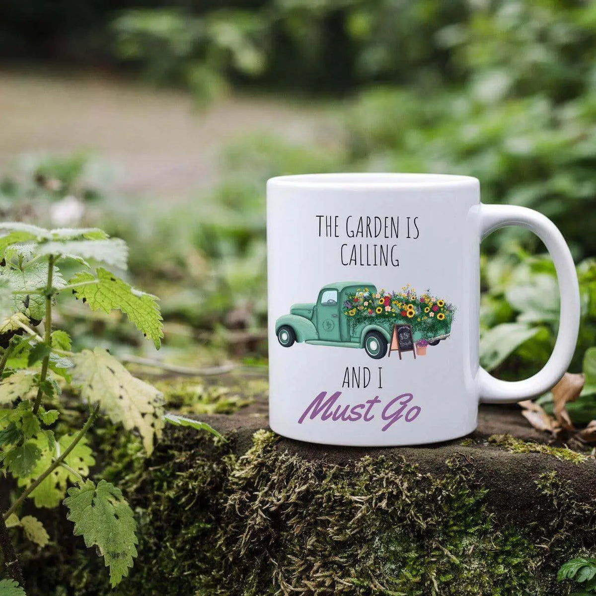 Ceramic mug by Winks Design Studio LLC featuring "The Garden Is Calling" design, perfect for garden lovers.