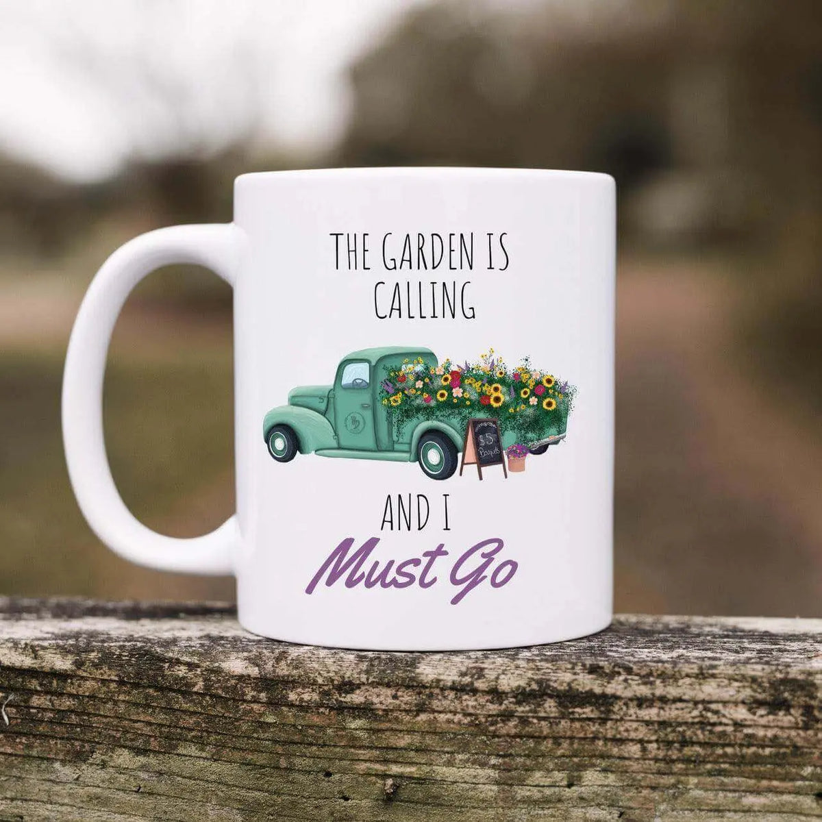 Ceramic mug from Winks Design Studio with "The Garden Is Calling" inscription, featuring a garden-themed design.
