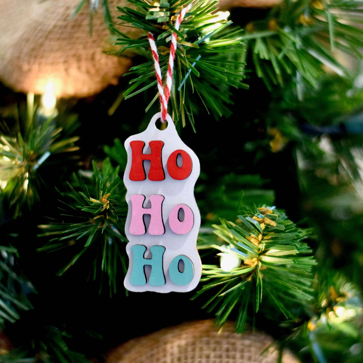 Wood engraved HoHoHo ornament from Winks Design Studio, LLC featuring festive holiday lettering and intricate design.