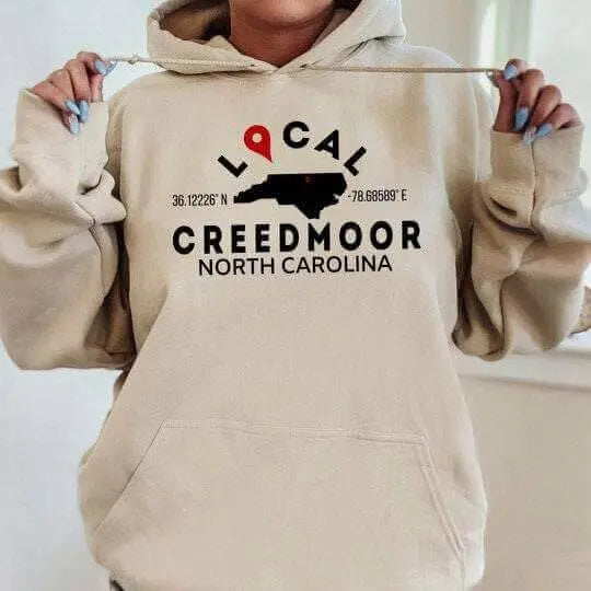 Tan custom city and state sweatshirt hoodie by Winks Design Studio, LLC, featuring a small, personalized map design.