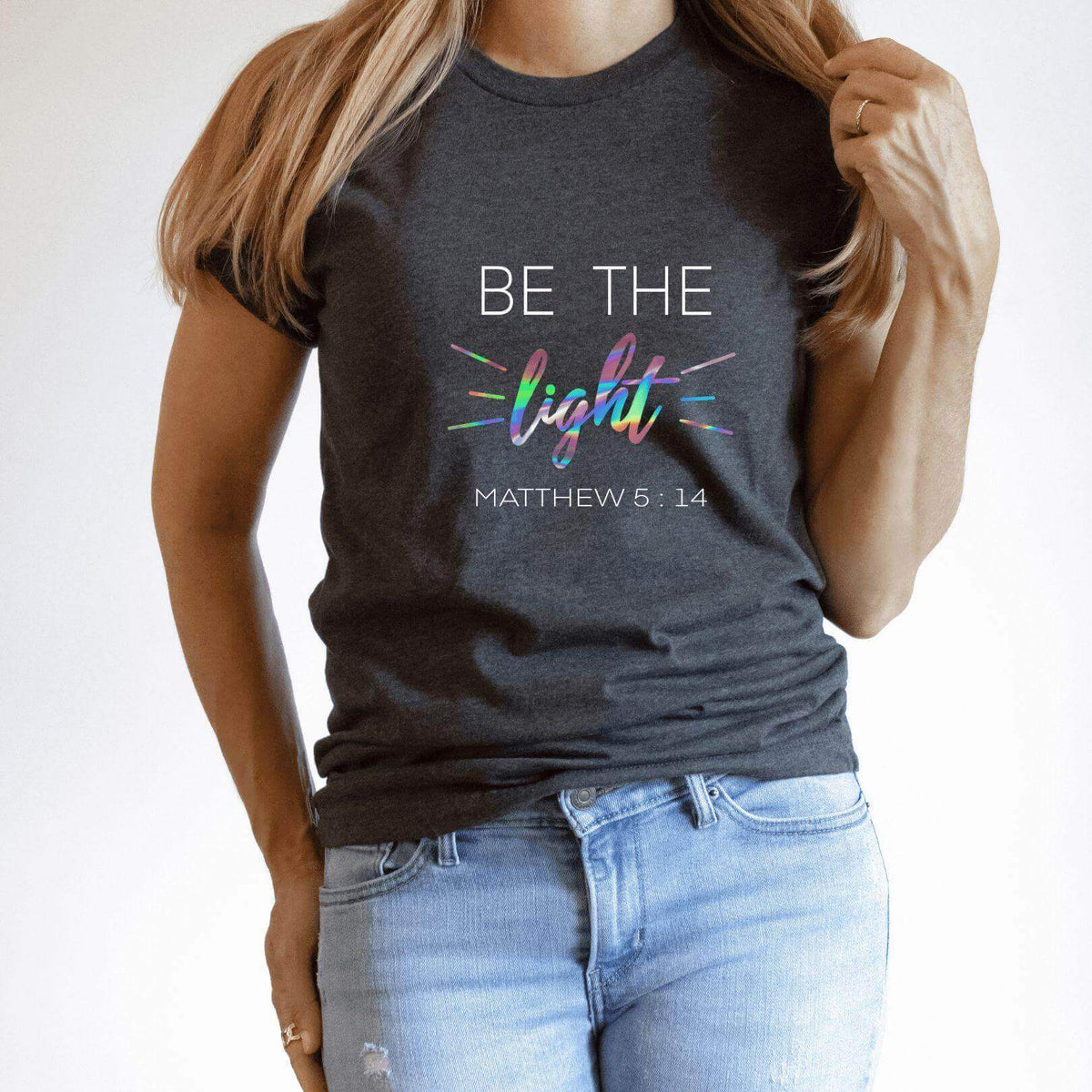 Be The Light T-Shirt by Winks Design Studio, LLC, showing a casual black T-shirt with the Be The Light graphic design.