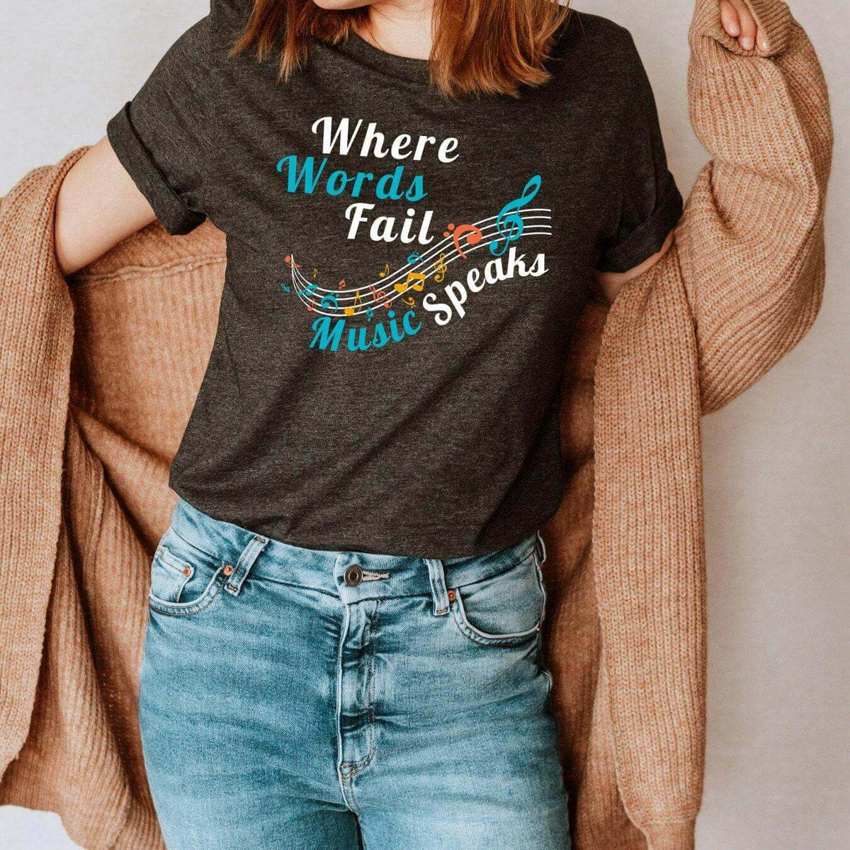 Winks Design Studio LLC T-shirt featuring the "Where Words Fail Music Speaks" slogan in black text on a casual cotton tee.