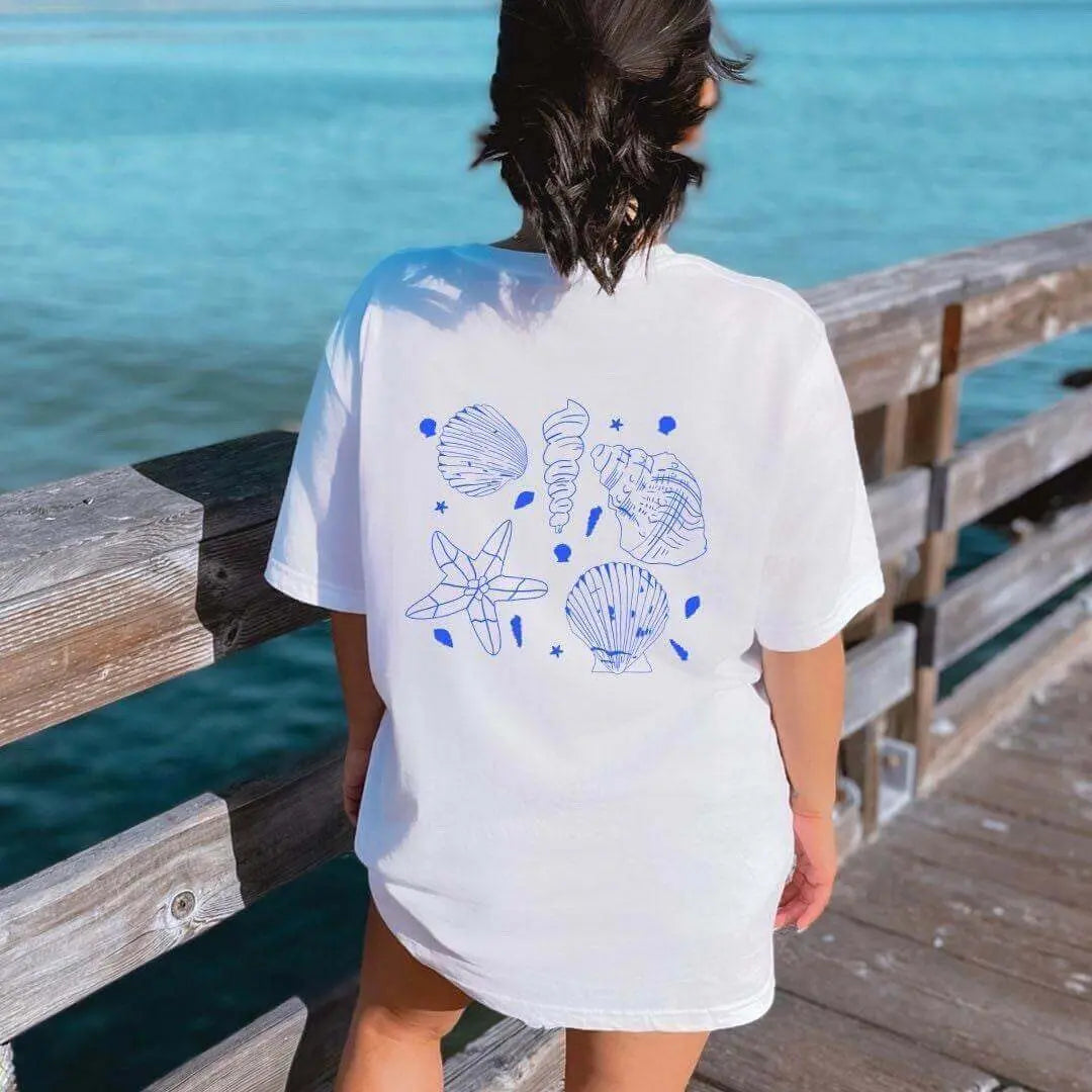 White Seashell T-Shirt by Winks Design Studio featuring nautical beachwear style, casual summer T-shirt with seashell print.