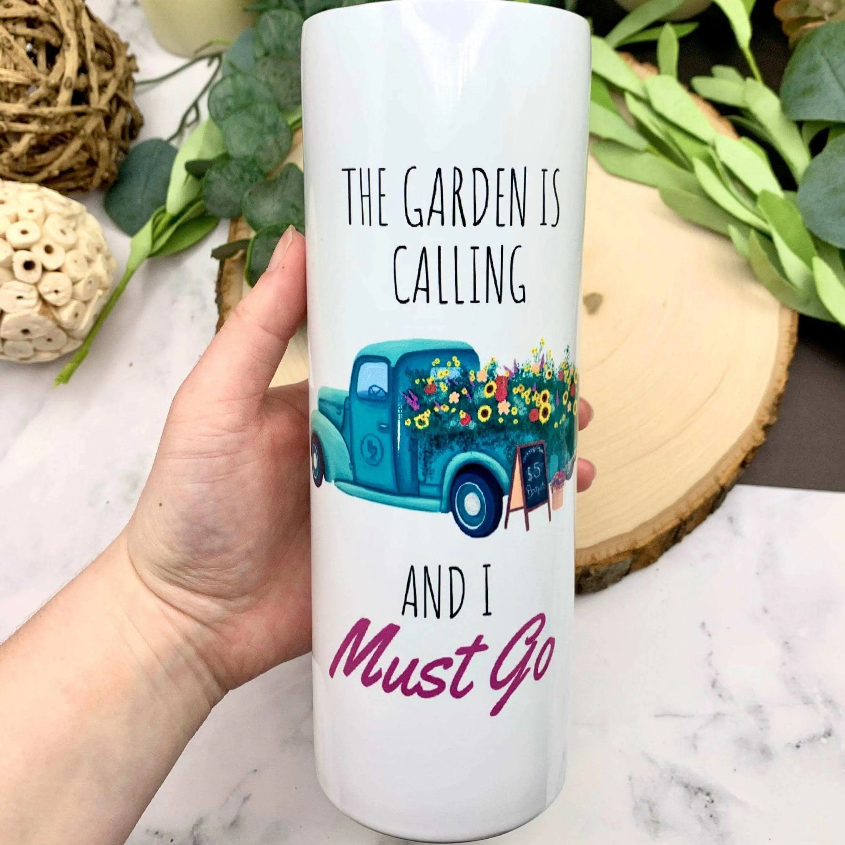 Winks Design Studio insulated tumbler featuring a nature-inspired design with "The Garden is Calling" text, ideal for beverages on the go.