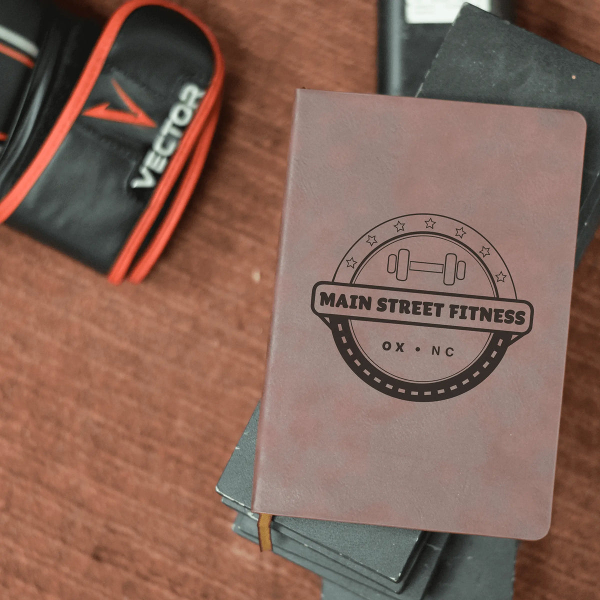 Winks Design Studio LLC yellow and brown leather journal with "Main Street Fitness" embossed on the cover, featuring a sleek tumbler design.