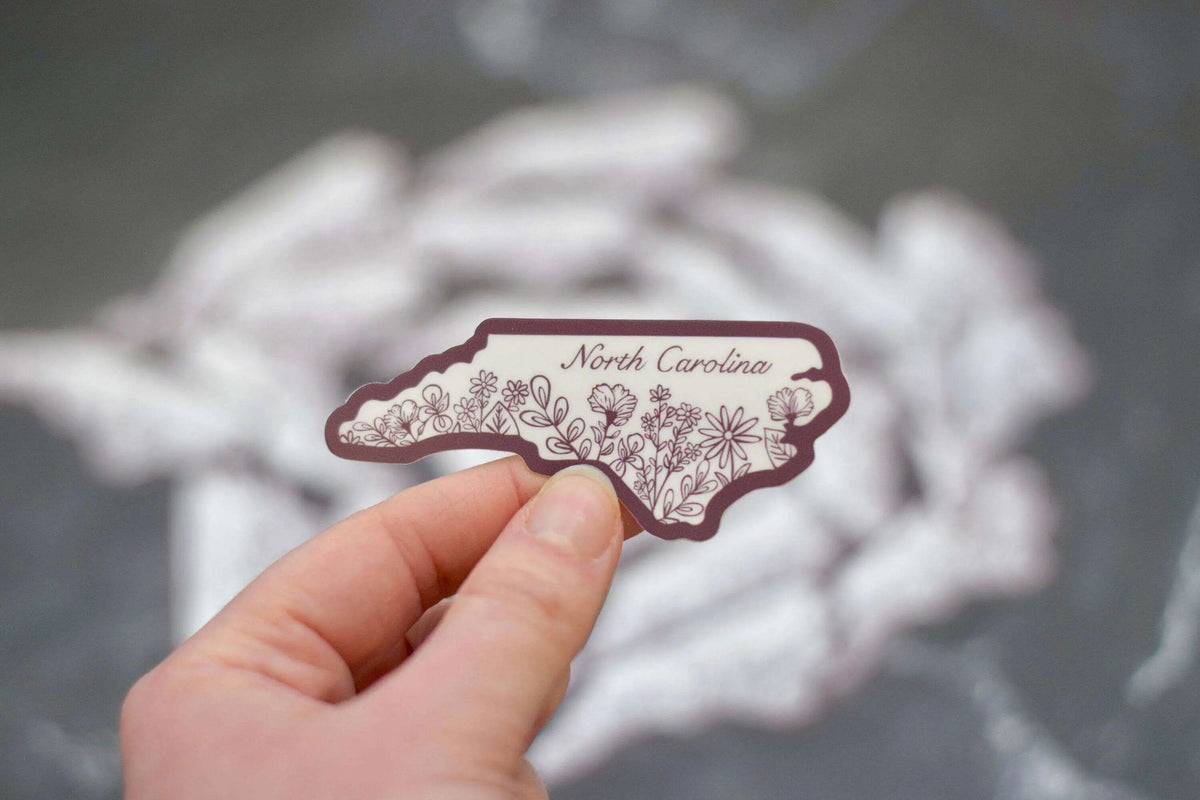 Mini North Carolina Wildflower vinyl sticker by Winks Design Studio, LLC, featuring colorful wildflower design on a clear background.