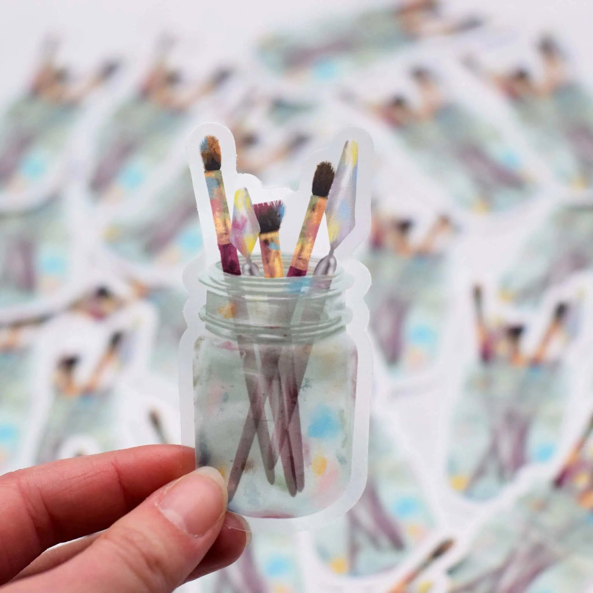 Vinyl sticker of paint brushes in a glass jar by Winks Design Studio, LLC, featuring detailed brush illustrations.