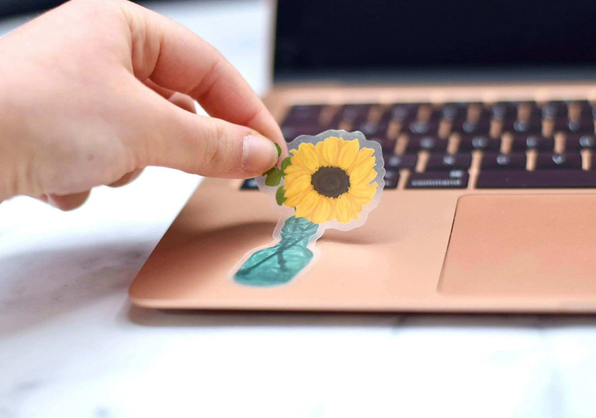 Transparent sunflower vinyl sticker by Winks Design Studio, LLC, featuring a detailed sunflower design on clear adhesive backing.
