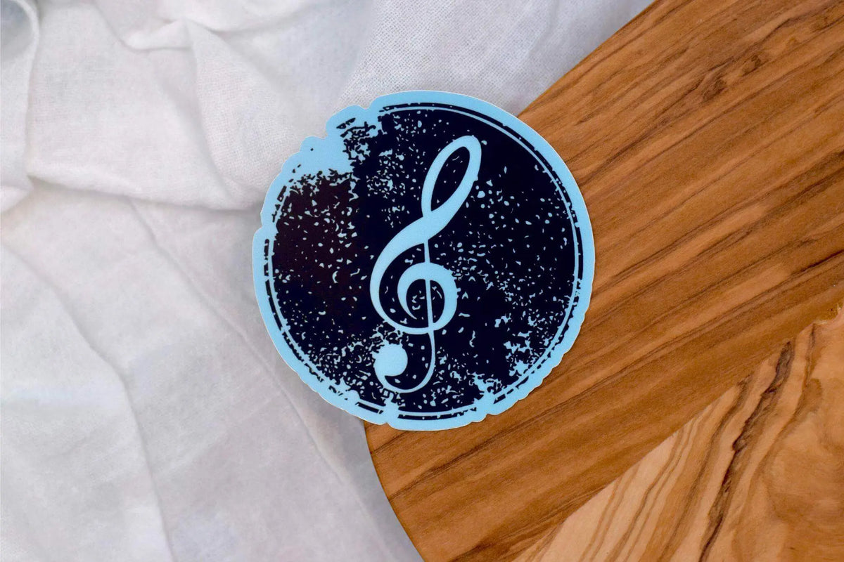Vinyl sticker of a treble clef music symbol by Winks Design Studio LLC, featuring vibrant, detailed musical notation on a clear background.