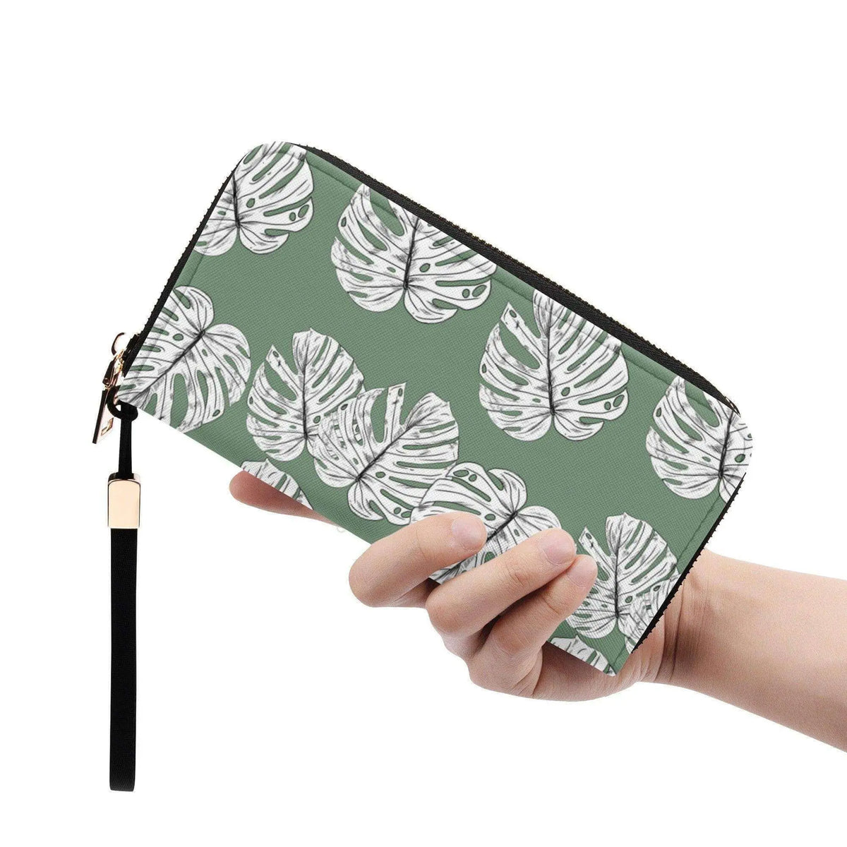 Green Monstera leaves clutch wallet with wristlet from Winks Design Studio, LLC, featuring a vibrant tropical leaf pattern.