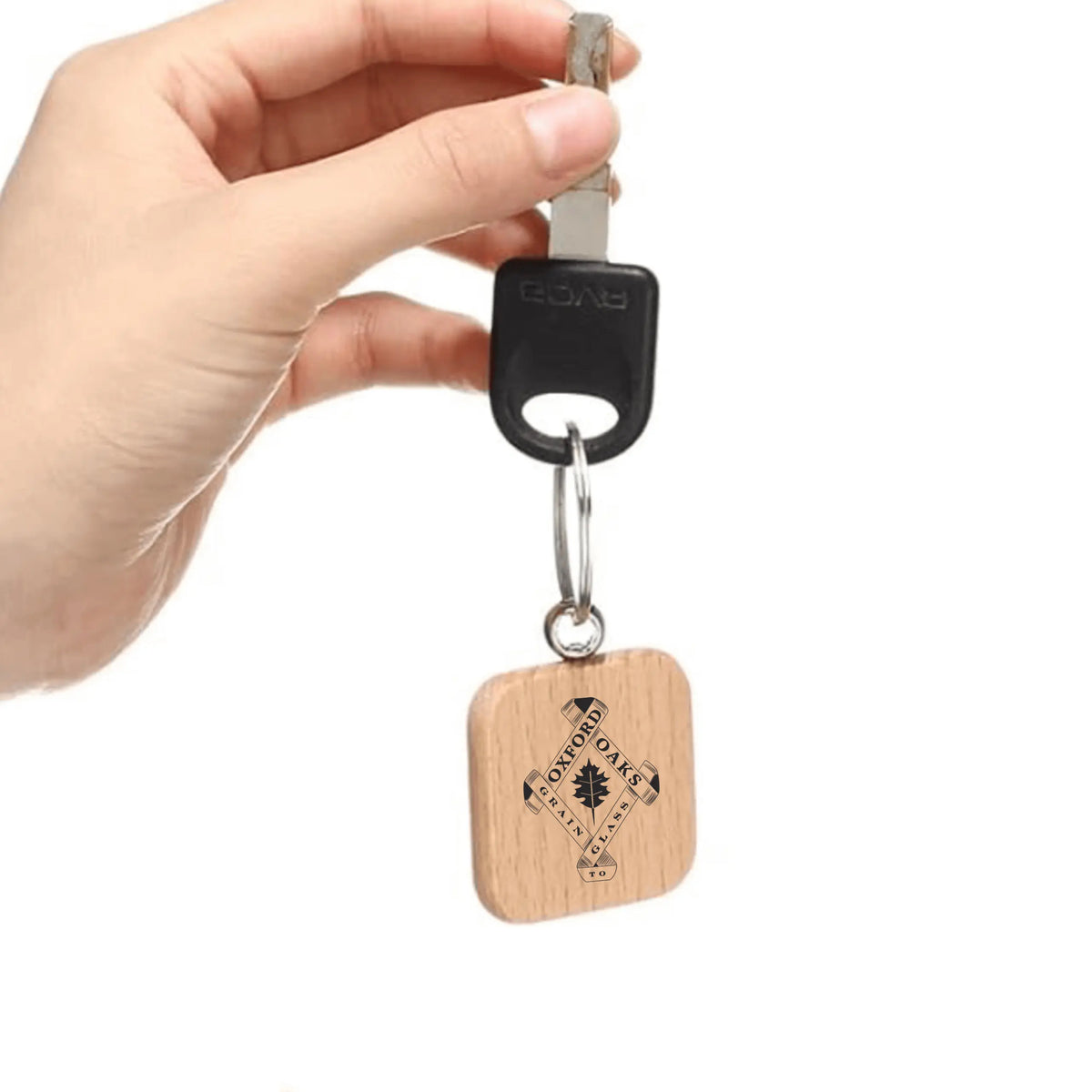 Wooden keychain from Oxford Oaks Distillery by Winks Design Studio, LLC, featuring engraved branding and natural wood finish.